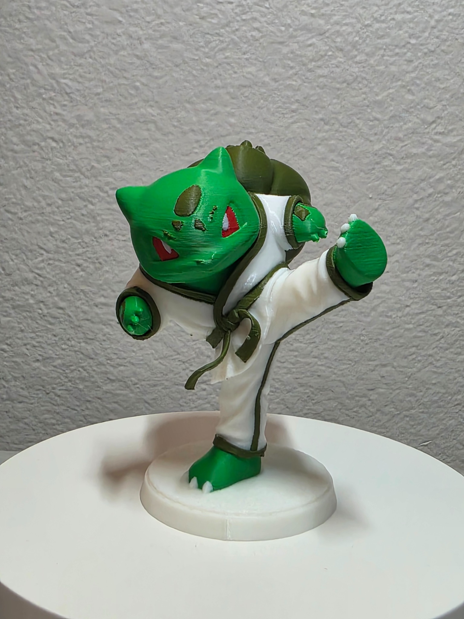 Green character in a taekwondo uniform performing a high kick